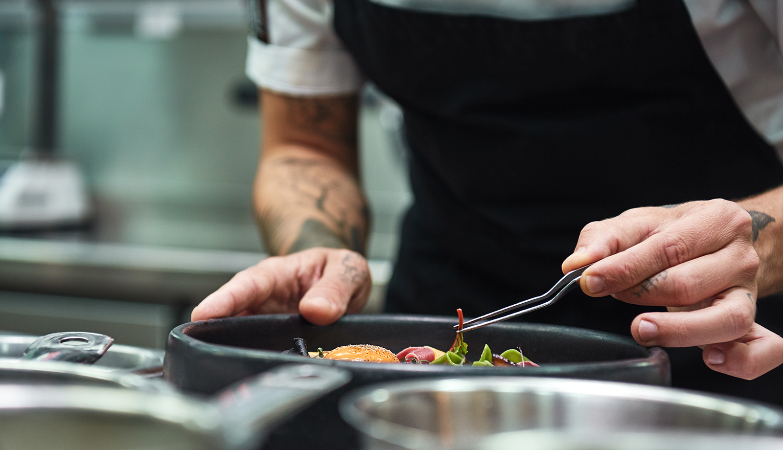 Hands of the chef garnishing food in a restaurant kitchen Hands of the chef garnishing food in a restaurant kitchen