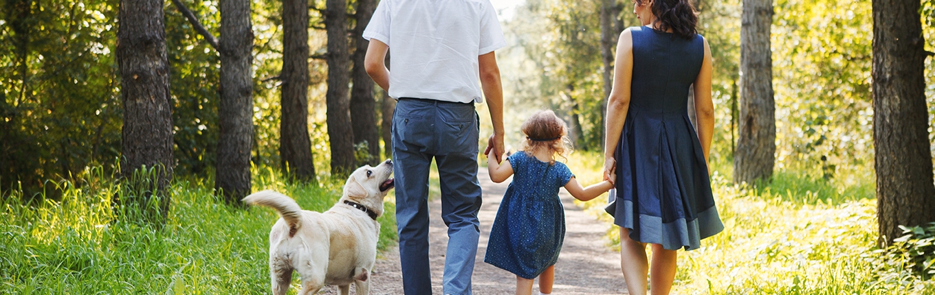 Family walking with dog and child.