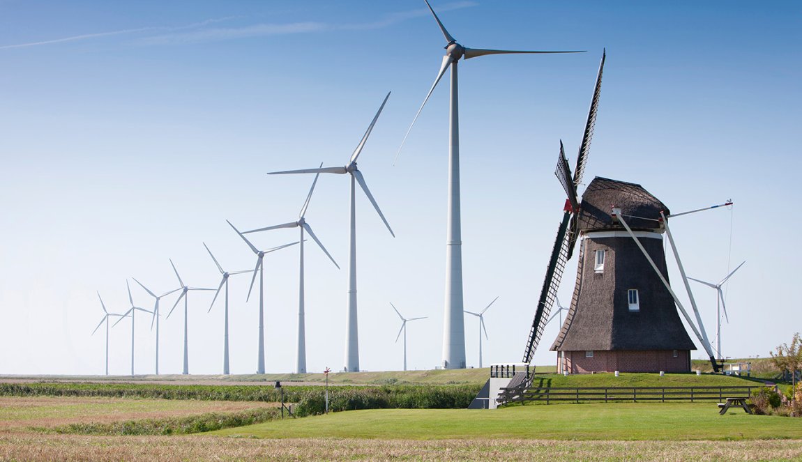 Traditional wind mill surrounded by wind turbines Traditional wind mill surrounded by wind turbines