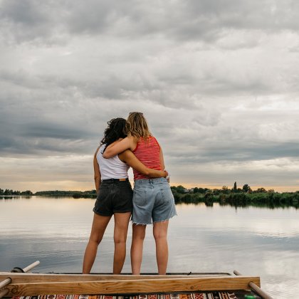 Girlfriends look out over the water together in Waterland