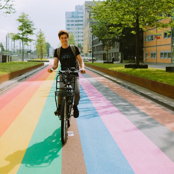 Man bikes across rainbow bike path in Utrecht