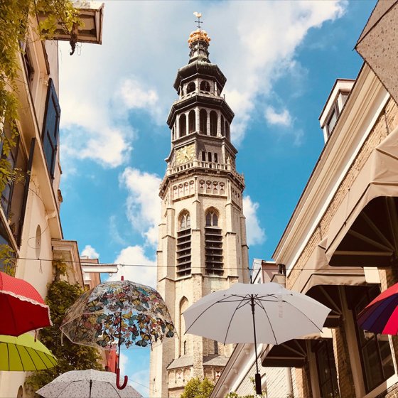 Heron Street during the day with hanging umbrellas and the tower 