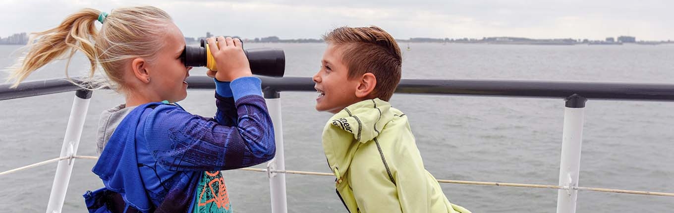 Children with binoculars in the wind on the deck of the Westerschelde Ferry