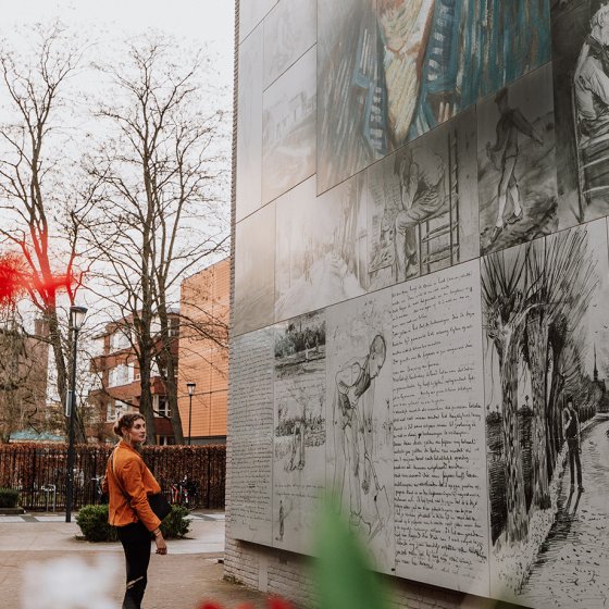 Woman views self-portrait of Van Gogh in street art Van Gogh church in Etten-Leur