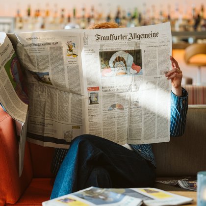 Lady reading German newspaper Frankfurter Allgemeiner