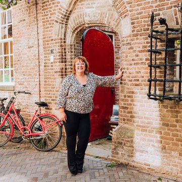 Judith Elders against building with red door