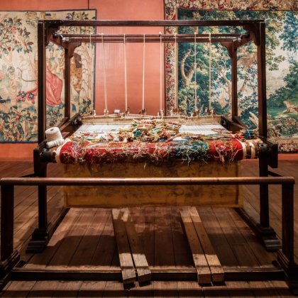 Historic tapestries and a traditional weaving loom, illustrating the craftsmanship featured in the Wonder Walls exhibition at Museum Gouda