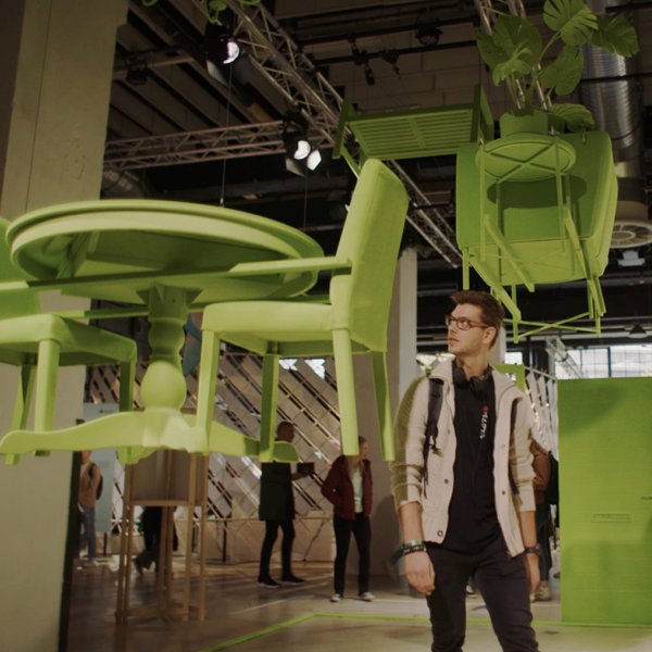Visitor among green flying furniture during Dutch Design Week