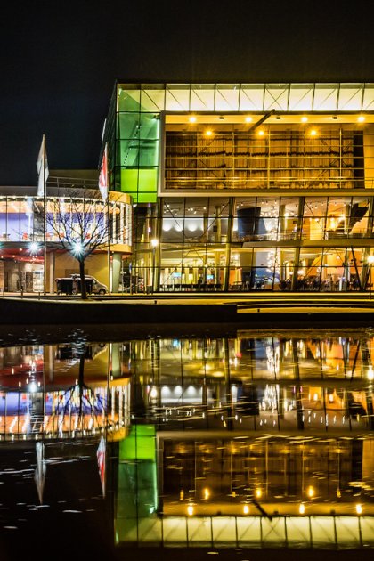 De Harmonie venue in Leeuwarden reflected in the water at night