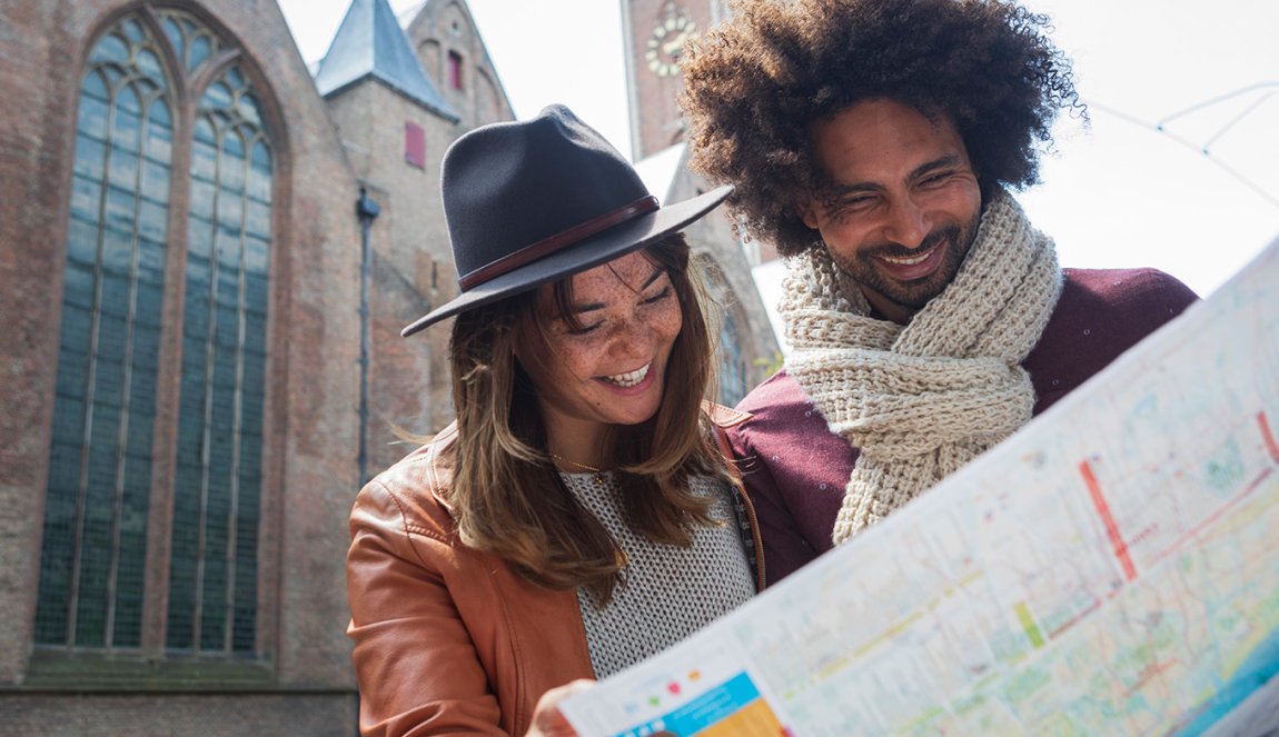 Young couple views city map in front of Grote Kerk Young couple views city map in front of Grote Kerk