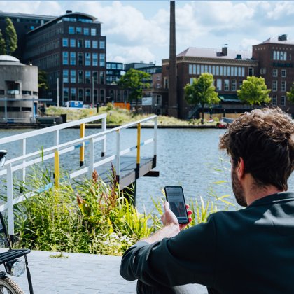 Lior Steinberg sitting by water with mobile phone