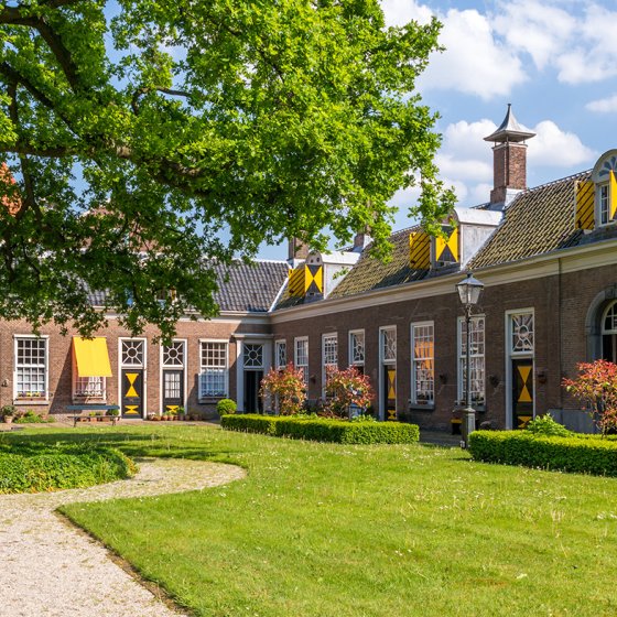 Green courtyard surrounded by old almshouses in Hofje van Staats in city of Haarlem